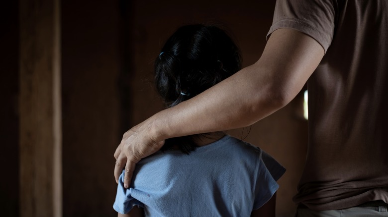 Child with arm on shoulders