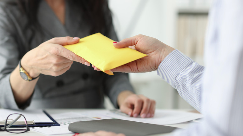 Yellow envelope being passed