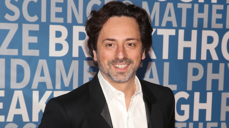sergey brin smiling in suit at event