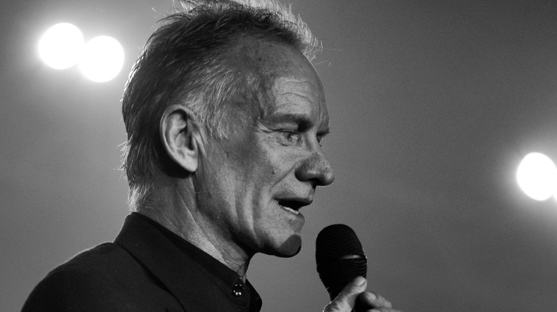 Sting performing on stage with microphone