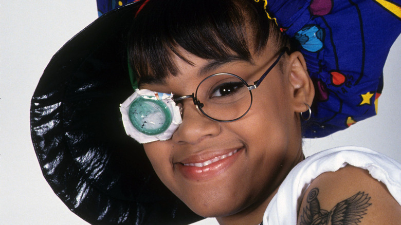 Lisa Left Eye Lopes wearing big hat and condom glasses