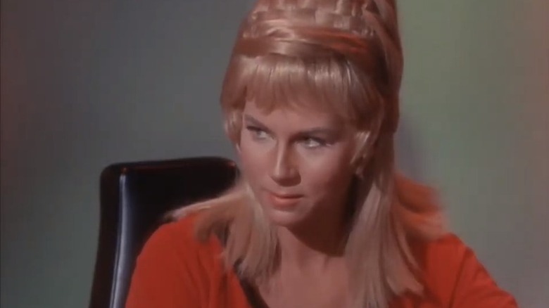 Grace Lee Whitney as Yeoman Janice Rand sat in red top