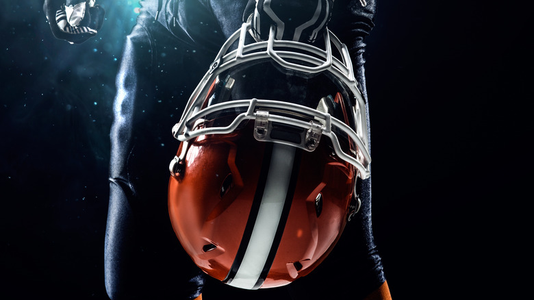 Football player holds helmet
