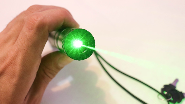 a hand holding a laser pointer
