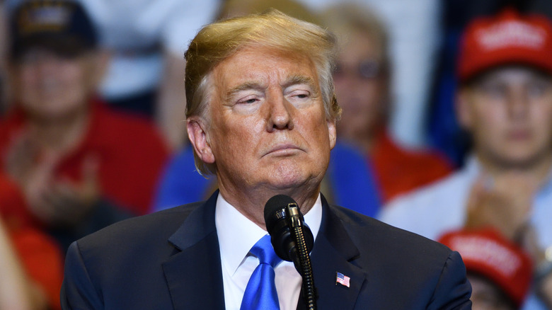Donald Trump looking angry behind a microphone