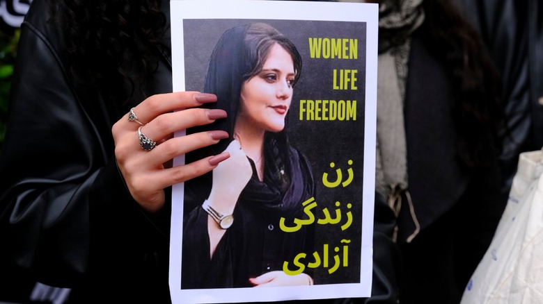 woman holding photo of Mahsa Amini
