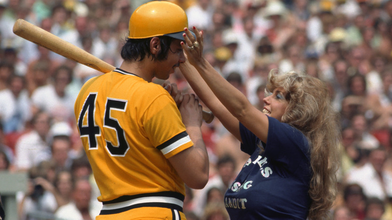 Morganna Roberts (also known as The Kissing Bandit) approaches pitcher John Candelaria, 1977