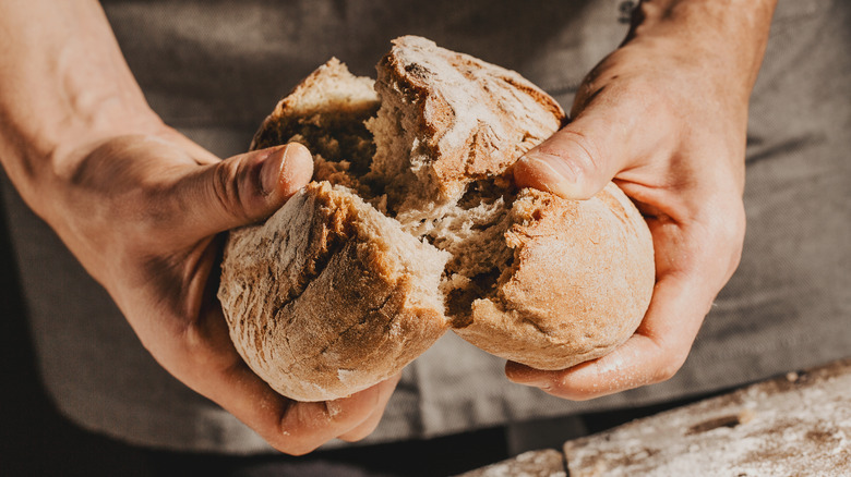 man breaking bread