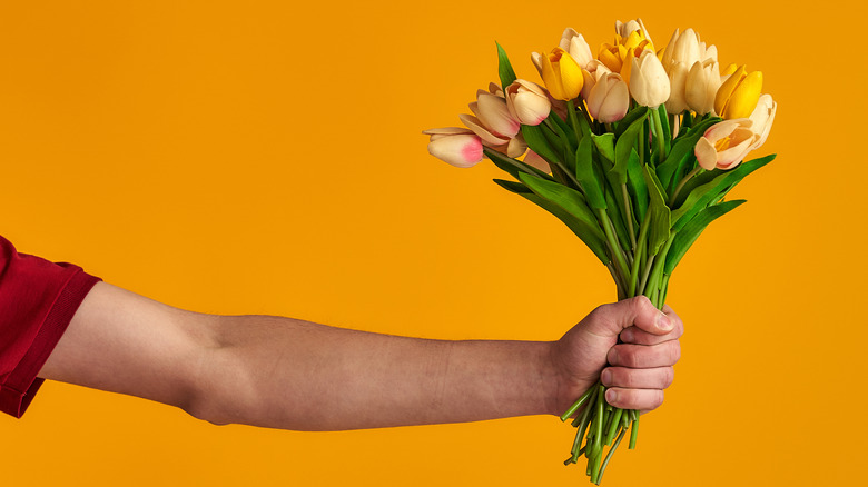 Arm extending a bouquet of flowers