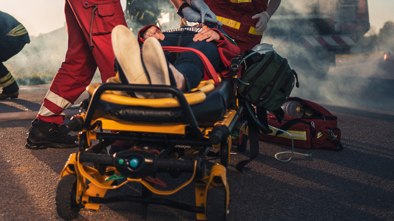 Paramedics Saving Life of a Victim who is Lying on Stretchers. They Apply Oxygen Mask, Do Cardiopulmonary Resuscitation / CPR and Perform First Aid