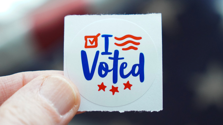 Person holding "I voted" sticker