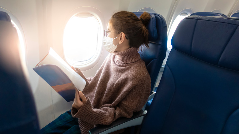 Женщина в маске в самолете