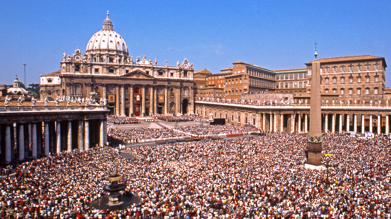 statue overlooks Vatican square crowd