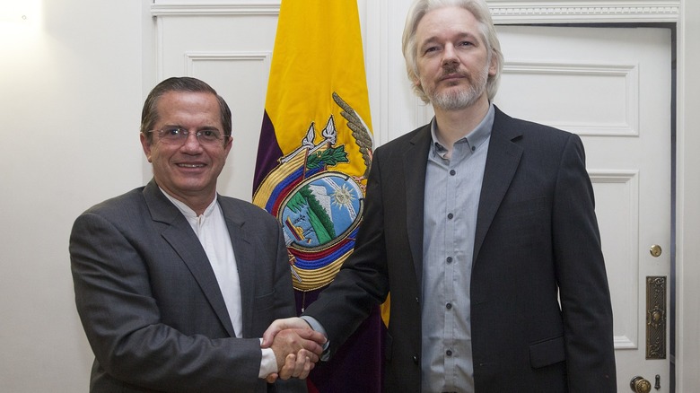 Assange shakes hands with Ecuadorian official