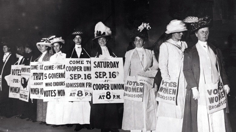 Suffragettes in fancy hats rallying for voting rights