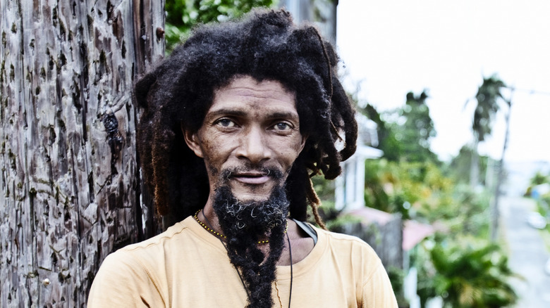 Man with dreadlocks smiling on beach