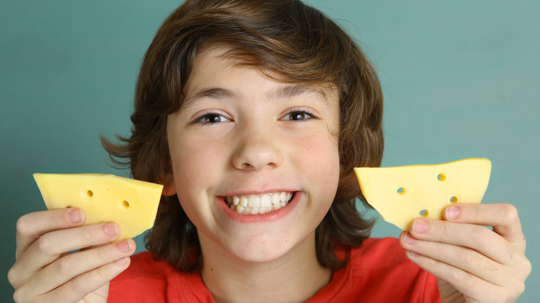 Child holding cheese slices