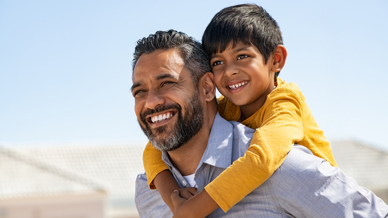 Dad giving piggyback to child 