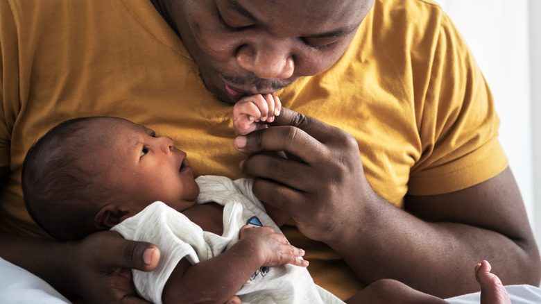 Father kissing baby's hand