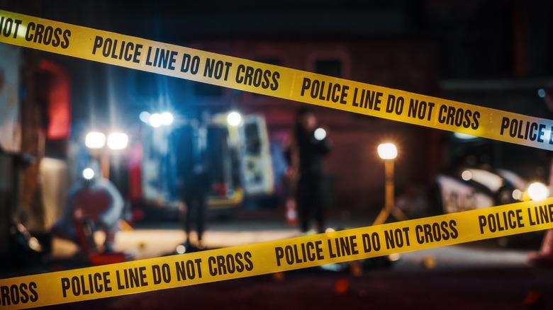 crime scene tape with investigators 