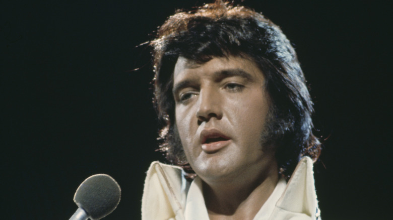 Elvis in white suit with microphone