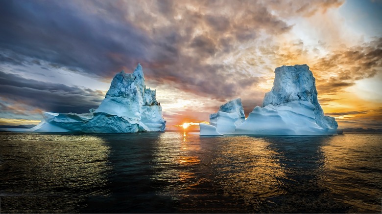 Photo of sunrise over two icebergs