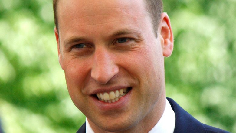 Prince William smiling green background