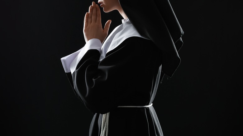 Nun praying while wearing black