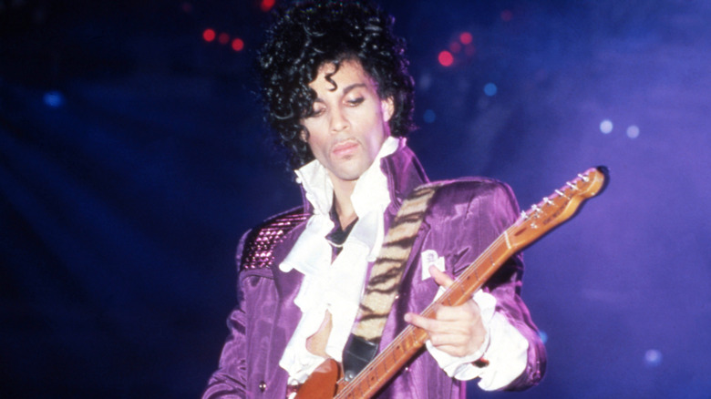 Prince holding guitar on stage