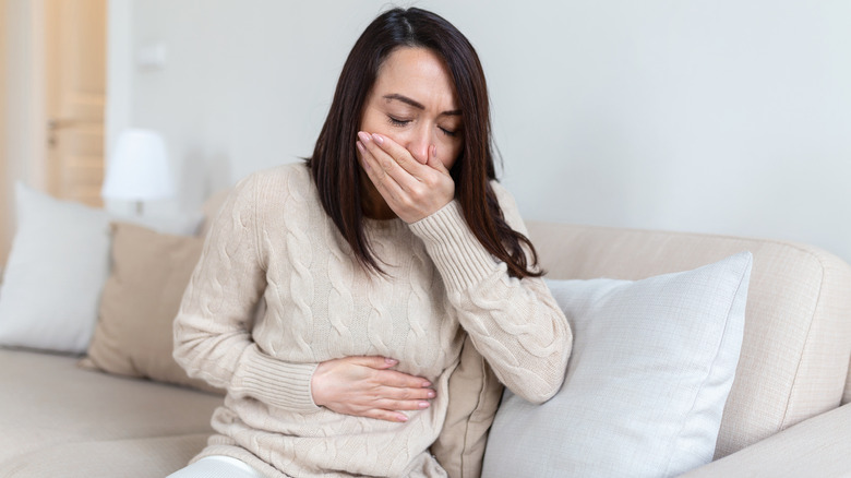 Person holding stomach and mouth