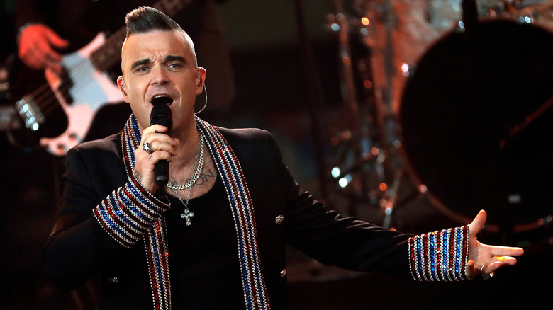 Robbie Williams on stage with mic