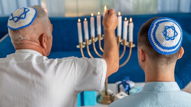 Jewish people lighting menorah
