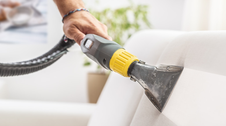 cleaning sofa with vacuum cleaner