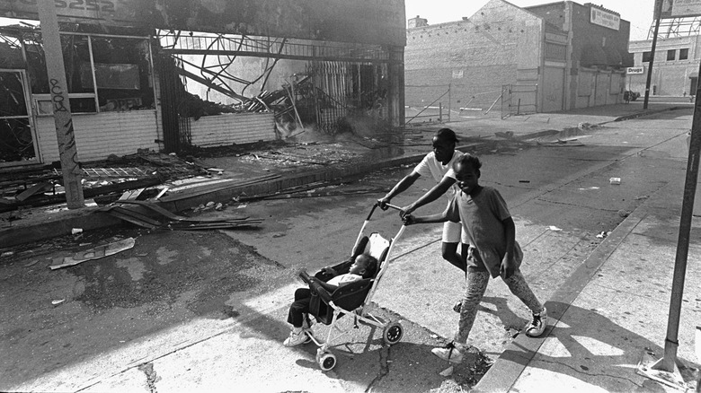 people pushing stroller amid LA riot damage