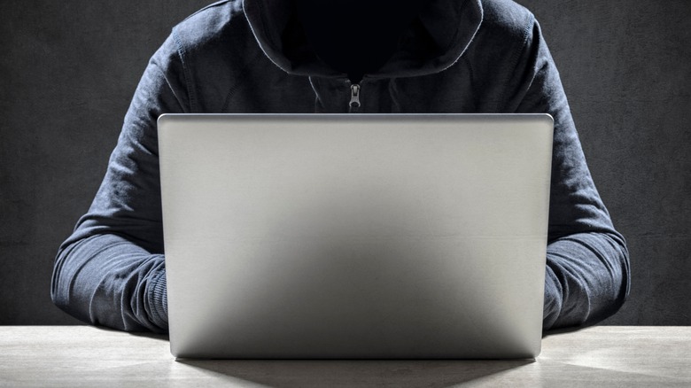 Hooded person typing