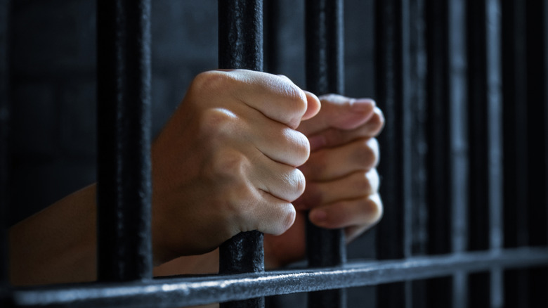 Woman's hand holding prison railings