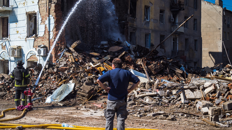 People at a damaged residential building in the Donetsk Region
