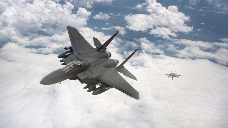 fighter plane in front of clouds