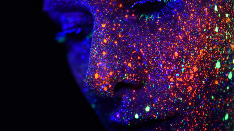 Glitter-covered face in dark