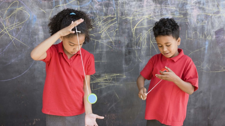 Two children playing with yo-yos