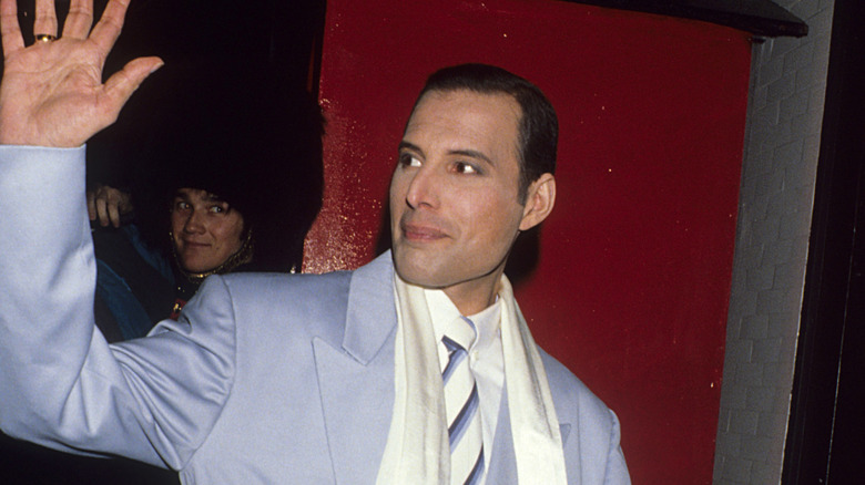 Freddie Mercury photographed against a red background in 1990