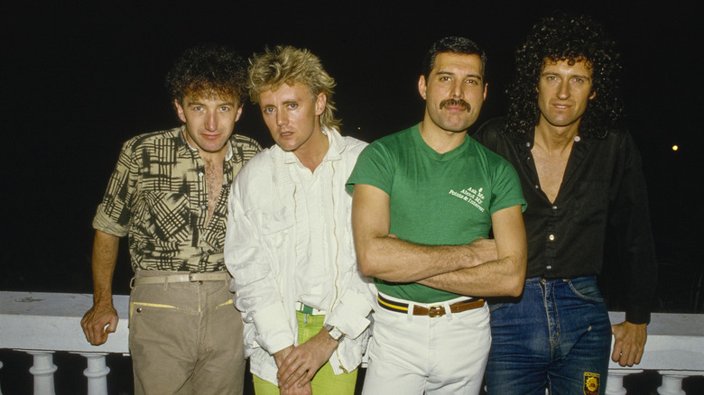 The members of Queen posing in front of a black background