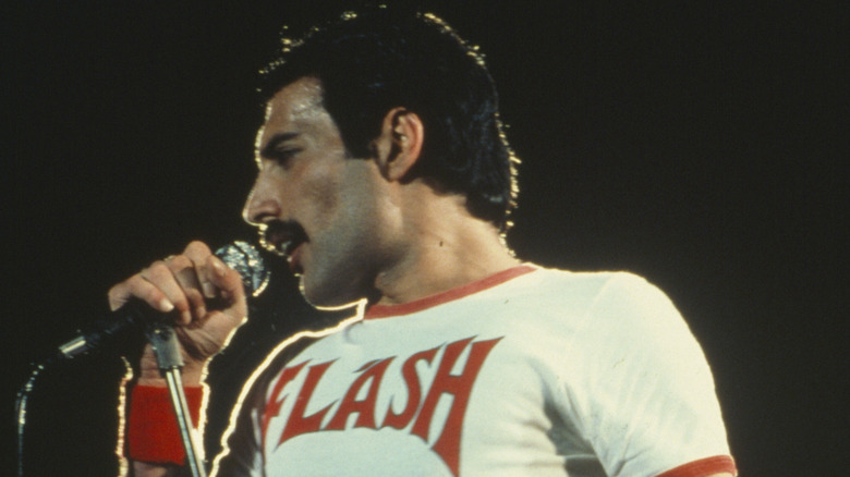 Freddie Mercury in concert wearing a Flash t-shirt