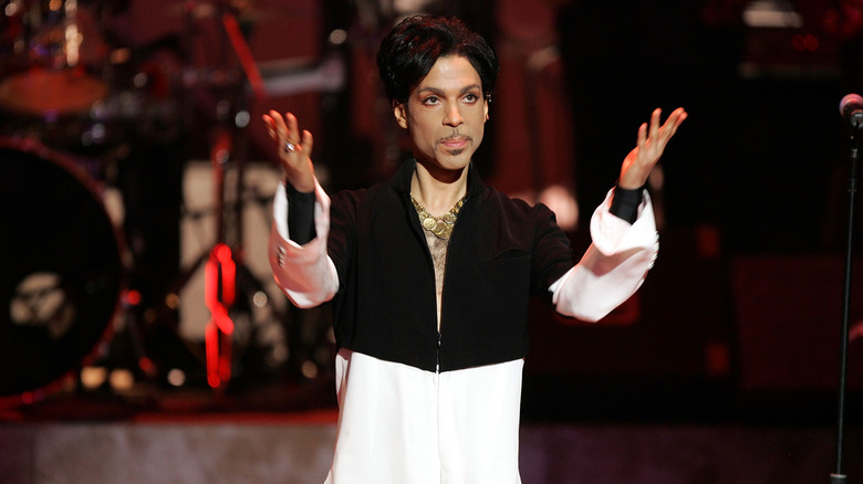 Prince gesturing to the crowd while onstage