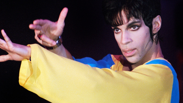 Prince wearing a blue and yellow outfit onstage
