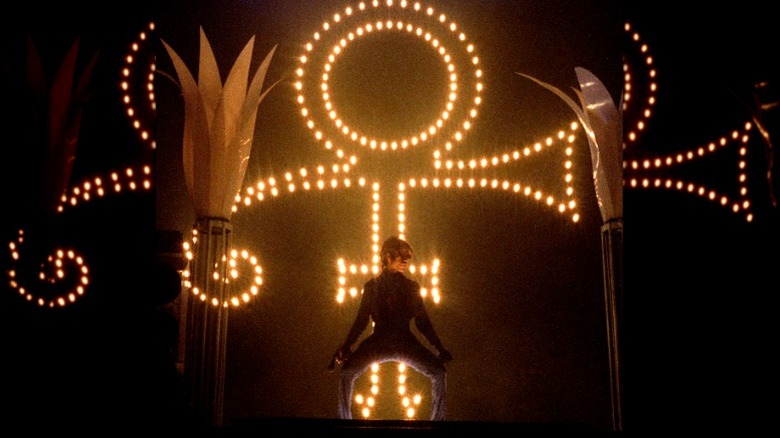 Prince performing in front of his symbol