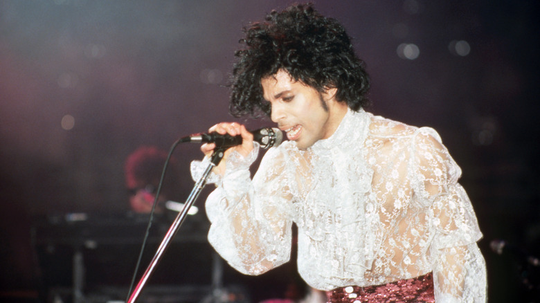 Prince singing into a microphone during a concert
