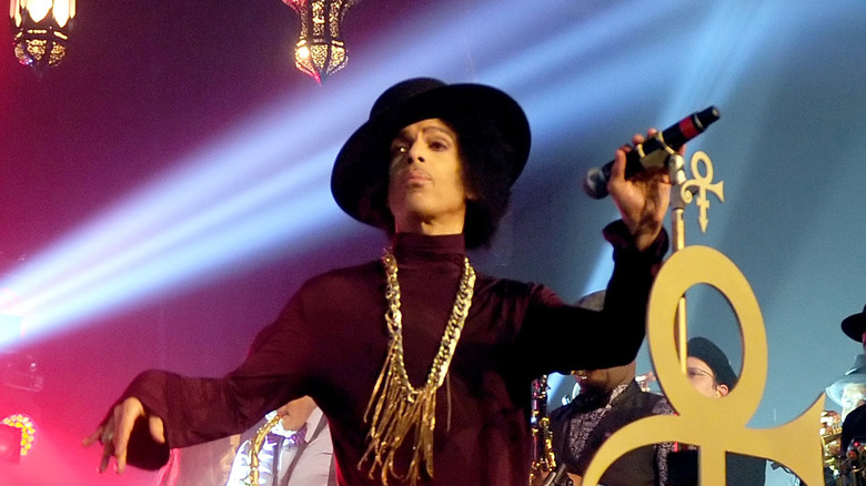 Prince wearing a black hat while performing at a concert