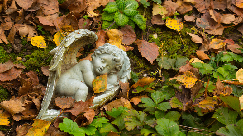 stone angel on pile of leaves