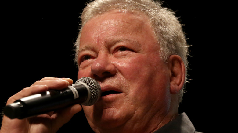 william shatner holds a microphone